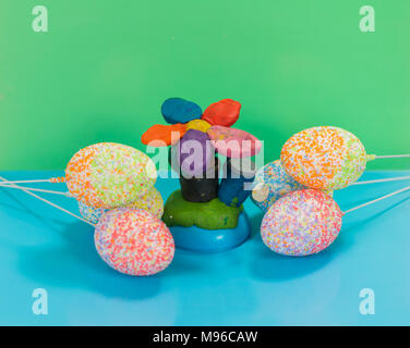 multicolor decorated easter eggs with handmade plasticine flower on colorful background Stock Photo