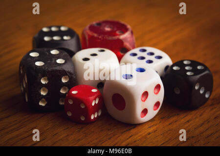 top view detail closeup of pile of many different color and sizes vintage used rolling dices on wooden background Stock Photo
