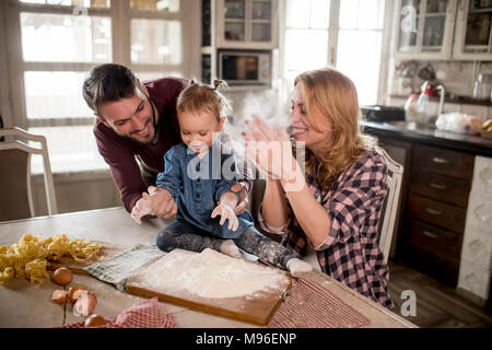 Happy family making pasta in the kitchen at home Stock Photo