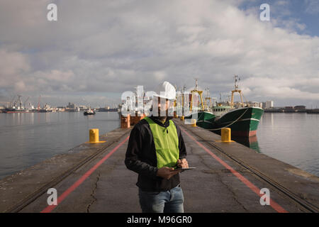Dock worker using digital tablet Stock Photo