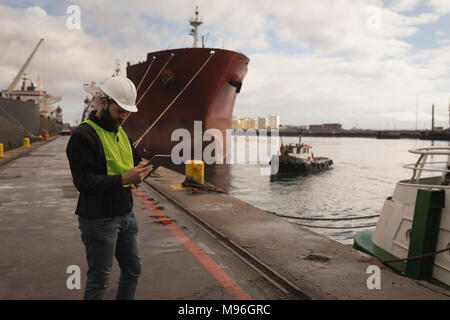 Dock worker using digital tablet Stock Photo