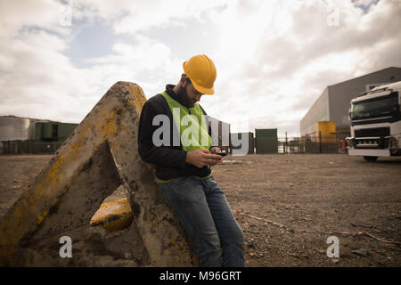Dock worker using mobile phone Stock Photo