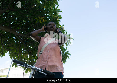 Woman wearing headphones in city street Stock Photo