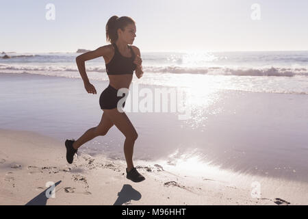 Fit woman jogging in the beach Stock Photo