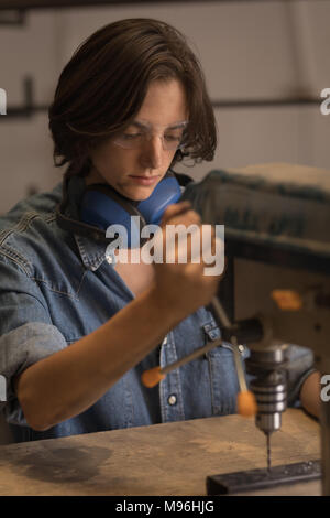 Female welder using vertical drilling machine Stock Photo
