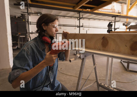 Female welder using drilling machine Stock Photo