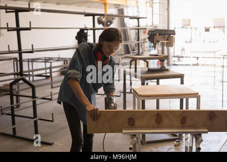 Female welder using drilling machine Stock Photo
