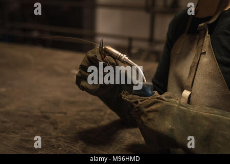 Female welder holding welding torch in workshop Stock Photo