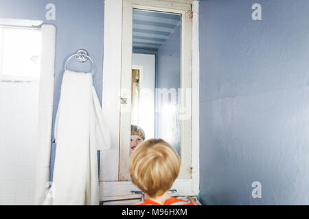 Boy smiling at himself in the mirror Stock Photo