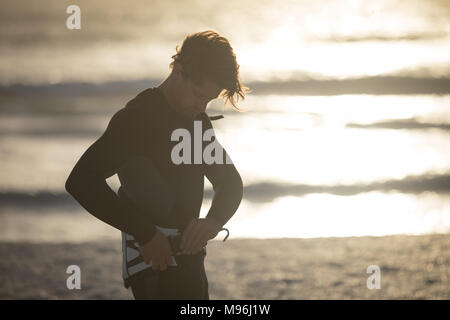 Male surfer wearing waist harness on the beach Stock Photo
