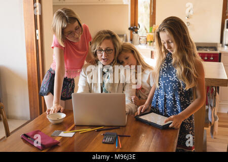 Mother and daughters using laptop and digital tablet Stock Photo