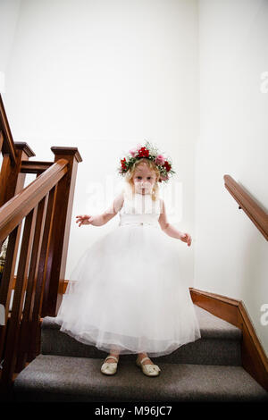 Girl in white dress waiting on top of stairs Stock Photo