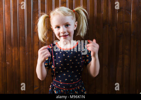 Girl with pigtails pulling faces Stock Photo