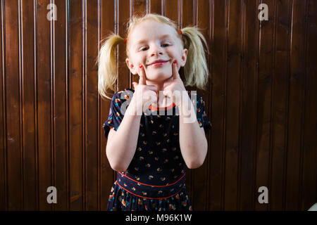 Girl with pigtails pulling faces Stock Photo