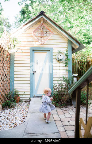 Girl in garden next to shed Stock Photo