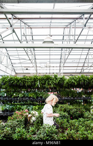 Girl in and around greenhouse within Garden Center Stock Photo