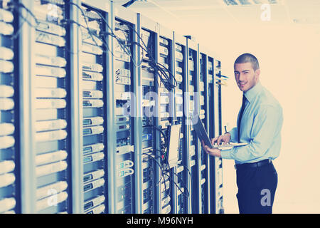 young engeneer business man with thin modern aluminium laptop in network server room Stock Photo