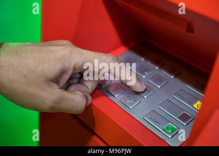 A man hand entering PIN/pass code on ATM/bank machine keypad Stock Photo