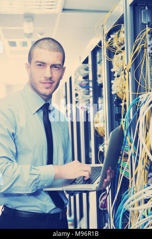 young engeneer business man with thin modern aluminium laptop in network server room Stock Photo