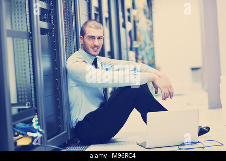 young engeneer business man with thin modern aluminium laptop in network server room Stock Photo