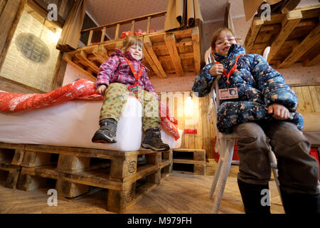 23 March 2018, Germany, Roevershagen: Marie (L-R) and Melina sit in a room during a press event prior to the opening of the upcycling hotel 'Alles Paletti' (lit. everyhting is all right) at the Karls Erlebnis-Dorf (lit. Karl's Adventure Village). The hotel is meant to only consist out of upcycled materials. Photo: Bernd Wüstneck/dpa Stock Photo