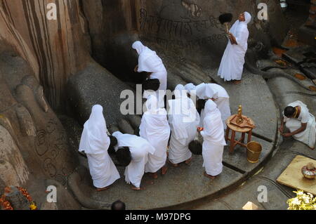 Jain devotees at the foot of gomateshvara bahubali statue, Shravanbelagola, Hassan, Karnataka, India Stock Photo