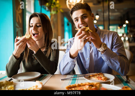 Close up photo of young couple enjoying in pizza, having fun together. Consumerism, food, lifestyle concept Stock Photo