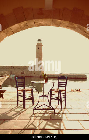 Old vintage cafe and lighthouse on the sea  Rethymnon Crete, impressions of Greece Stock Photo
