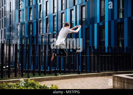 Freerunner is jumping between walls in the city. Stock Photo