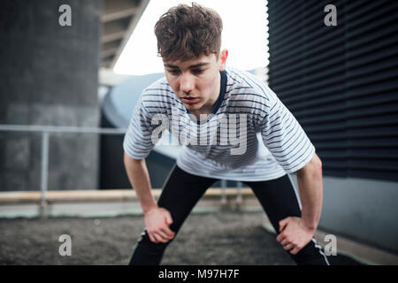 Freerunner is stretching on a rooftop. Stock Photo
