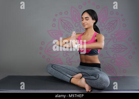 Calm woman sitting with her eyes closed and meditating Stock Photo