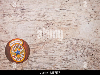 LONDON, UK - MARCH 22, 2018:  Newcastle brown ale original beermat coaster on wooden background Stock Photo