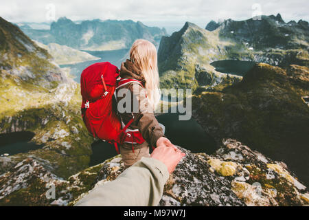 Couple travelers follow holding hands in  mountains Norway landscape love and Travel lifestyle concept family traveling active adventure hiking vacati Stock Photo