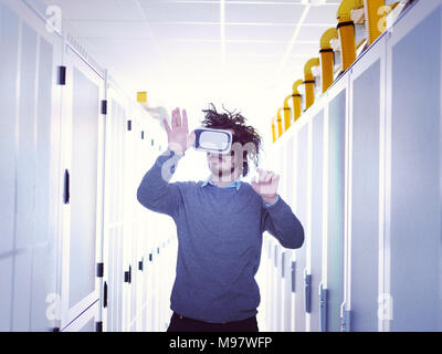 young IT engeneer using virtual reality headset over server room background Stock Photo