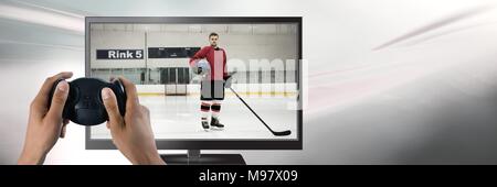 Hands holding gaming controller  with hockey player on television Stock Photo