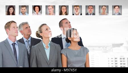 Business people looking up at portrait profiles of different people Stock Photo