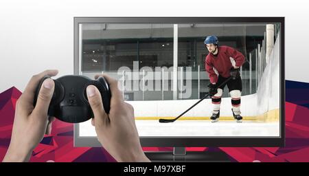 Hands holding gaming controller  with ice hockey player on television Stock Photo