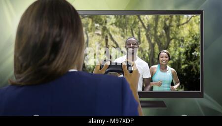 Woman holding gaming controller  with athletic fit peolpe on television Stock Photo