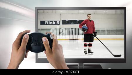 Hands holding gaming controller  with hockey player on television Stock Photo