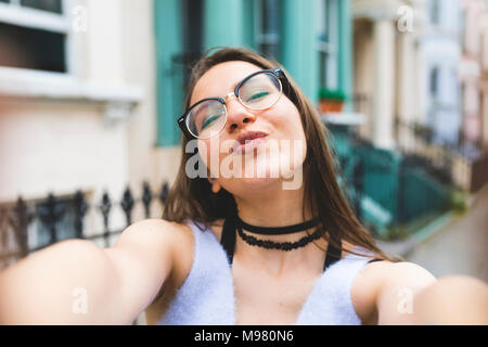 Happy teenage girl in the city taking a selfie Stock Photo