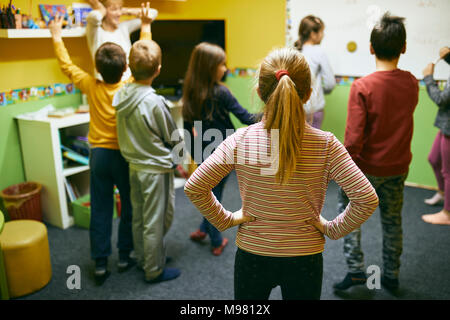 Teacher with students in relaxation room with whiteboard Stock Photo