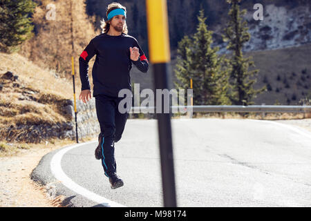 Man running on mountain road Stock Photo
