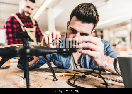 Man working on drone in workshop Stock Photo