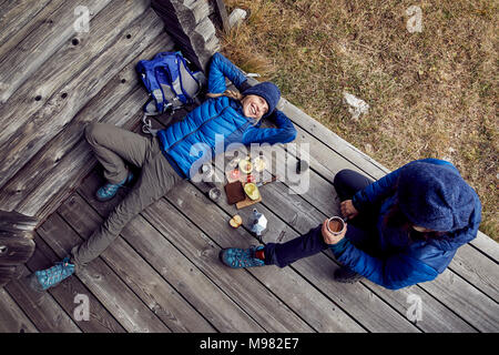 Overhead view of couple hikers having a break at mountain hut Stock Photo