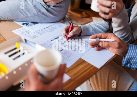 Team of architects working on a project, discussing blueprints Stock Photo