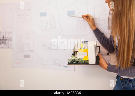 Female architect working on a project, holding architectural model Stock Photo