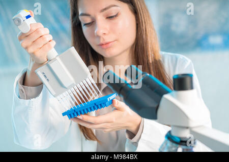 student woman with multi pipette and other PCR items in microbiological / genetic laboratory Stock Photo