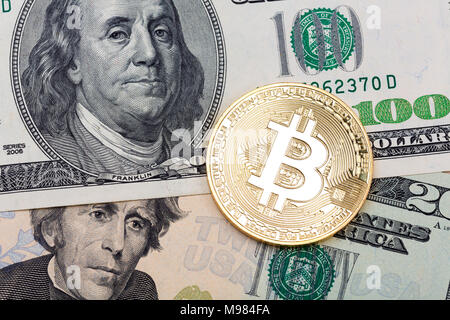 Close up of golden  bitcoin on US dollars background, macro shot Stock Photo