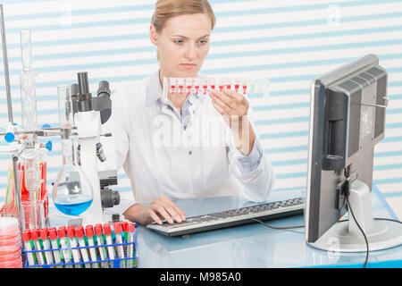 Experiments in the chemical laboratory, Female researcher using her test tube in a laboratory Stock Photo