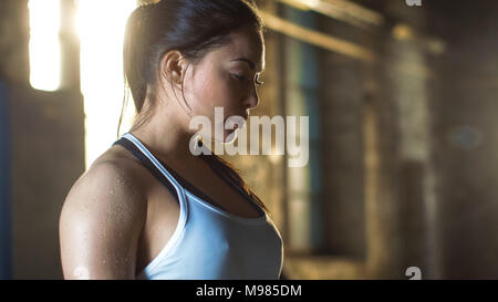 Tired Beautiful Athletic Woman Looking Down after Intensive Cross Fitness Exercise. Stock Photo